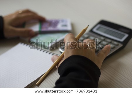 Accounting. business woman counts money on calculator