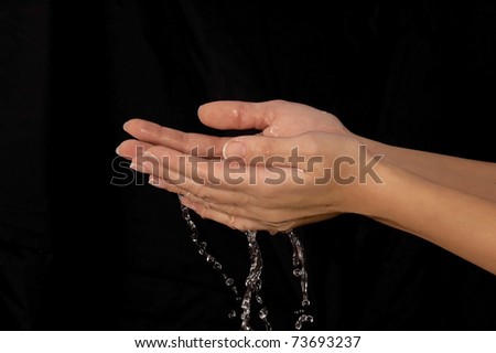 Beautiful hands with water on a black background