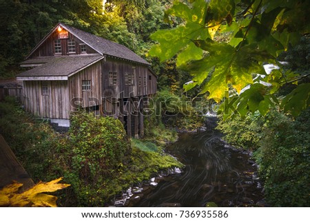 Cedar Creek Grist Mill during the early parts of fall from the bridge looking towards the mill and river