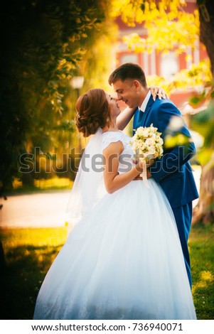 couple groom and bride against the background of orange leaves.