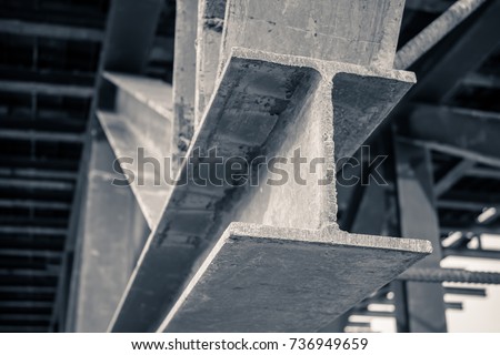 grungy monochrome style image of h beam or i beam iron metal structure frame under bridge base pole of highway construction site, close up shot low key dark tone image  Royalty-Free Stock Photo #736949659