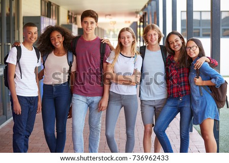 Teenage classmates standing in high school hallway Royalty-Free Stock Photo #736962433