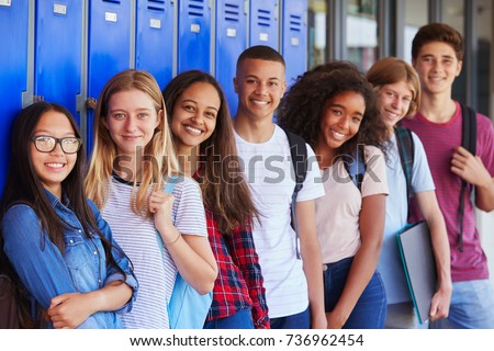 Teenage school kids smiling to camera in school corridor Royalty-Free Stock Photo #736962454