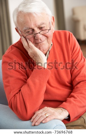 Senior Man Looking Sad In Chair At Home