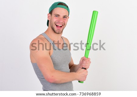 Man in cyan green baseball hat on white background. Player with smiling face plays baseball. Sports and game concept. Guy in grey tank top holds bright green bat, copy space