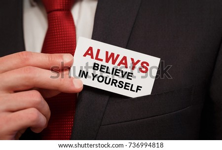 Businessman putting a card with text Always believe in yourself in the pocket