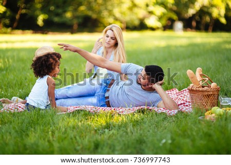 Picture of lovely couple with their daughter having picnic