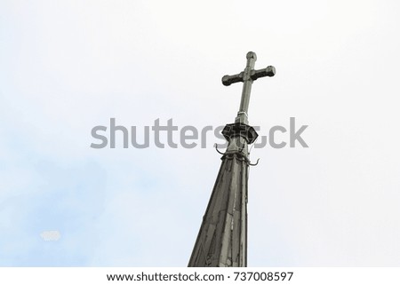 Cross on the top of small church in small countryside village city.