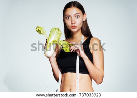 a young beautiful girl wants to lose weight, holds a useful low-calorie Peking cabbage