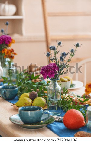 festive autumn table, autumn food and paraphernalia, pumpkins, flowers, tea
