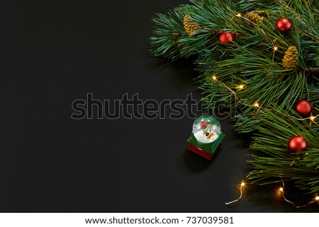 Christmas. Xmas toys and spruce branch on black background top view. Copy space.