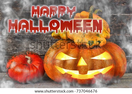 Spooky Halloween pumpkin head  surrounded by ghosts in the fog on wooden background 