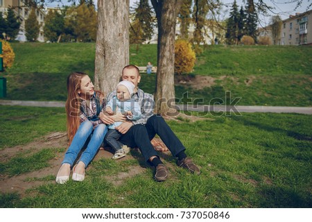 Beautiful mom with her husband and their little daughter in the autumn park
