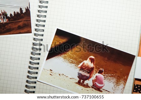 Album with printed photo of two sisters squatting near the water