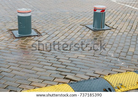 Poles restricting cars on stone pavement