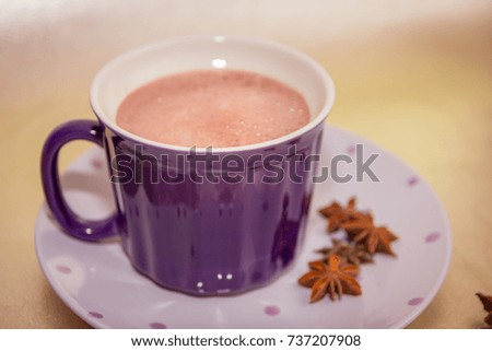 cocoa in violet mug on golden background with baden stars toned picture close-up shallow depth of field