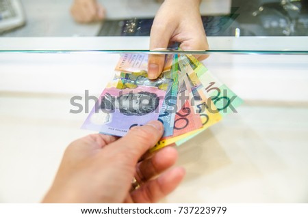 Australian dollar (AUD), Australia money, Women giving money currency of Australia. Exchange money for Australian dollar (AUD), business and finance concept.