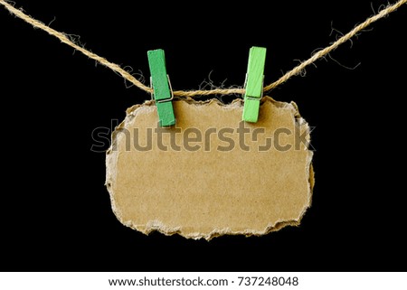 Blank brown paper hanging on rope with pin.