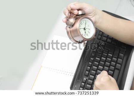 Lady Holds Watch And keyboards in the office.
Time Management Concepts
