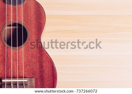 Ukulele on the wooden background with blank copy space.