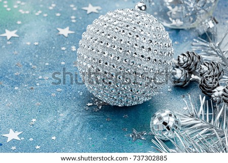 silver christmas balls and fir branch with cones on festive background with star confetti
