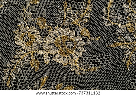 Image texture background, decorative gold lace with pattern. Golden vintage lacy background. Golden lace on a black background. Spandex, macro. Lacy decorative floral pattern.