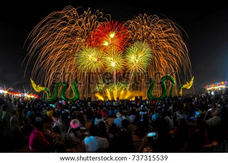 People sit and watch the fireworks show at Phra Nang Naga fireball festival on the Mekong River around October, Nongkhai, Thailand every year. Royalty-Free Stock Photo #737315539