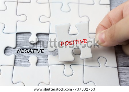 hand holding last piece of puzzle written "positive" with missing puzzle space written "negative". Behavior conceptual.selective focus, shallow depth Royalty-Free Stock Photo #737332753