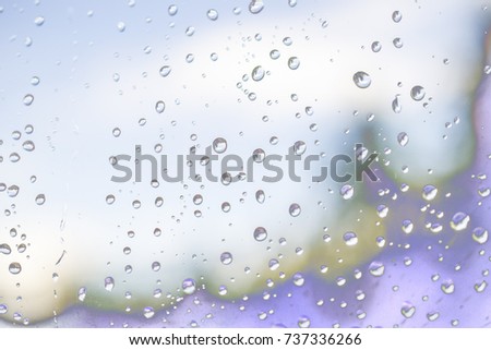 Fantastic picture behind the window glass, covered with rain drops