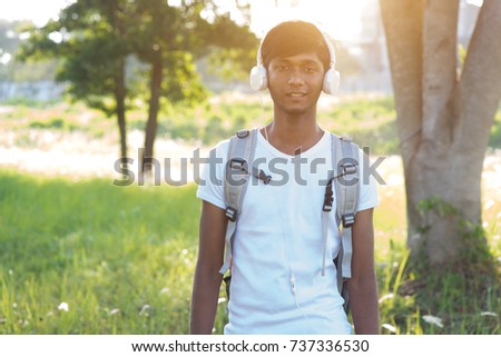 indian teenage male outdoor listening to music