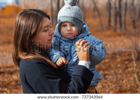 mom and little son are walking in the autumn park