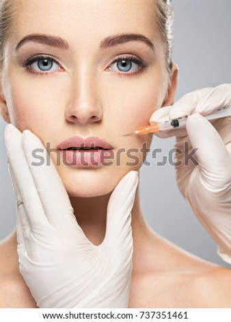 Woman getting cosmetic injection of botox in cheek, closeup. Woman in beauty salon. plastic surgery clinic. Royalty-Free Stock Photo #737351461