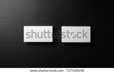 Blank business cards on black wooden background. Template for ID. Top view.