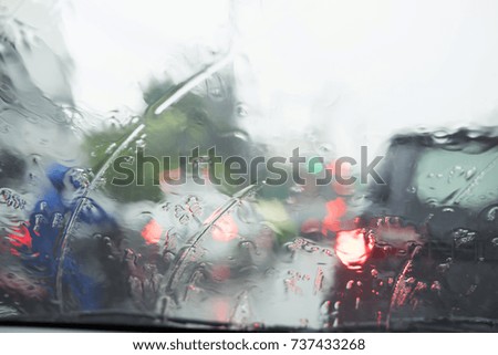 Rain drops on a car window in traffic