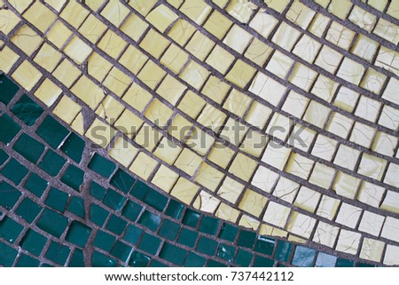 Green and yellow mosaic tiles on the wall as background or texture
