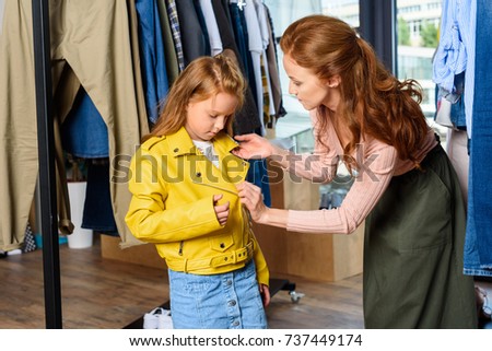 mother and daughter with yellow leather jacket shopping in boutique