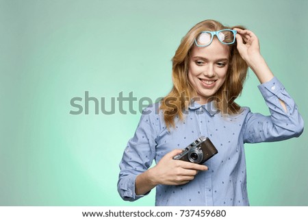 joyful woman photographer with a camera on a green background                               
