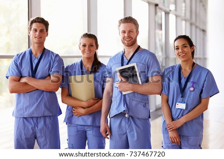 Group portrait of healthcare workers in hospital corridor