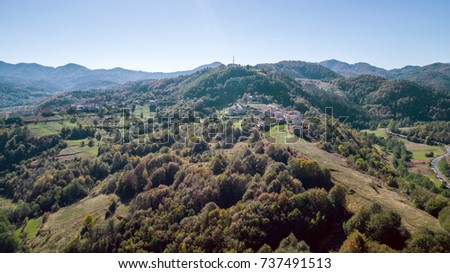 Aerial Shot Of A Small Village Into The Mountain At Autumn