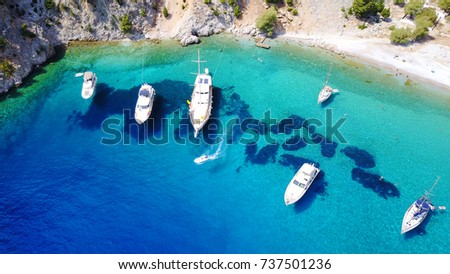 Aerial bird's eye view photo taken by drone of tropical rocky seascape with yachts docked and turquoise - sapphire clear waters