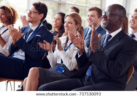 Smiling audience applauding at a business seminar Royalty-Free Stock Photo #737530093