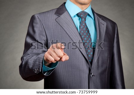 businessman in suit and tie pointing the finger in front of himself