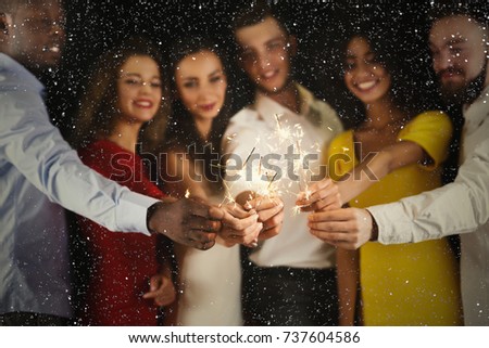 Holiday background with sparklers. Young friends holding bengal lights, closeup, selective focus. Birthday or winter holidays celebration, greeting card mockup