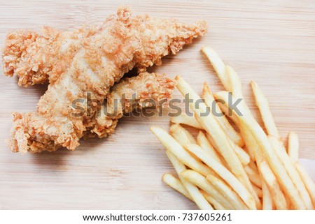 Fried Chicken Nuggets and French Fries on Wooden Board Plate Background. 
