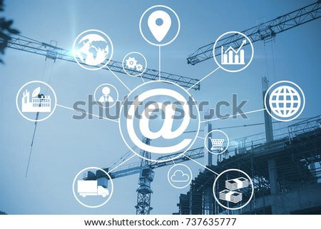 Composite image of at symbol amidst various icons against crane and building construction site