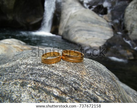 Golden wedding rings on textured stone