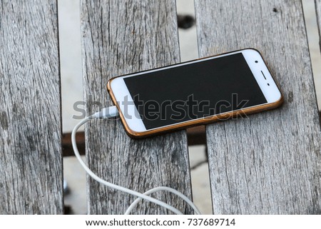 Smartphone on old wooden table and soft focus 