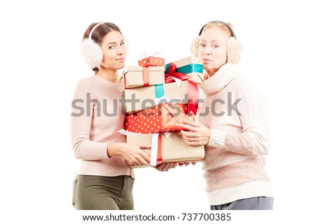 Portrait of senior mother and adult daughter exchanging Christmas gifts