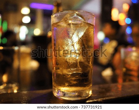 selective focus of mug of beer standing on wooden table in bar