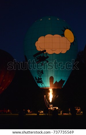 picture of a hot air balloon at night lit up with fire ready to take off to a new adventure into the unknown. Artistic photography
